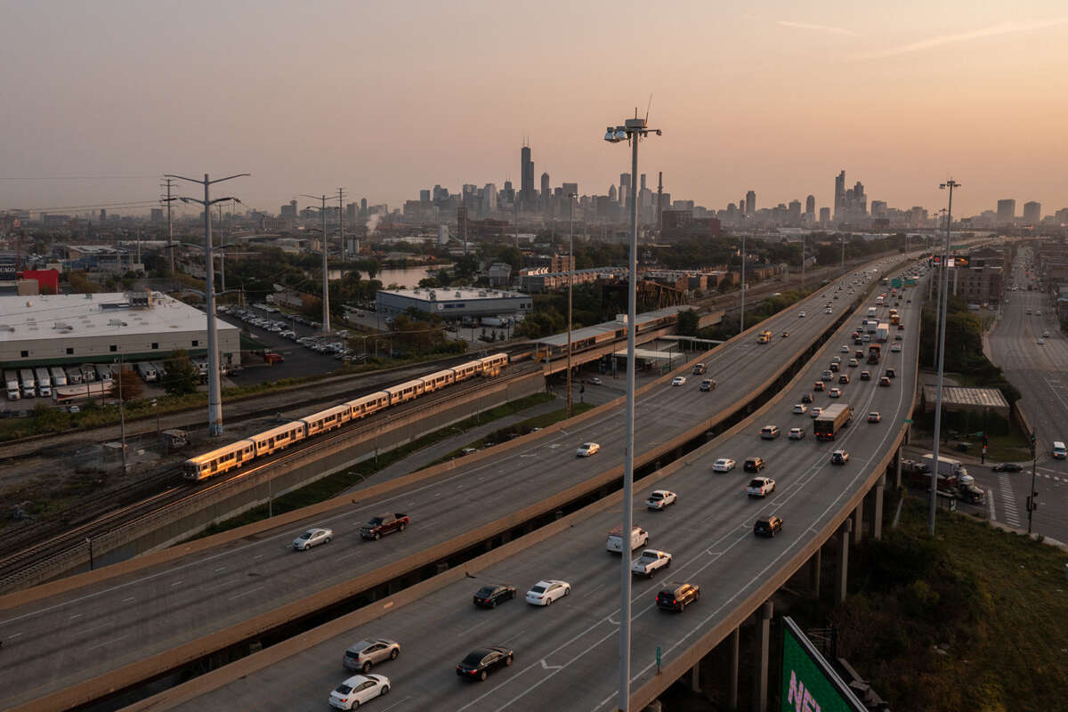 Aerial view of Chicago skyline and expressway at sunset.