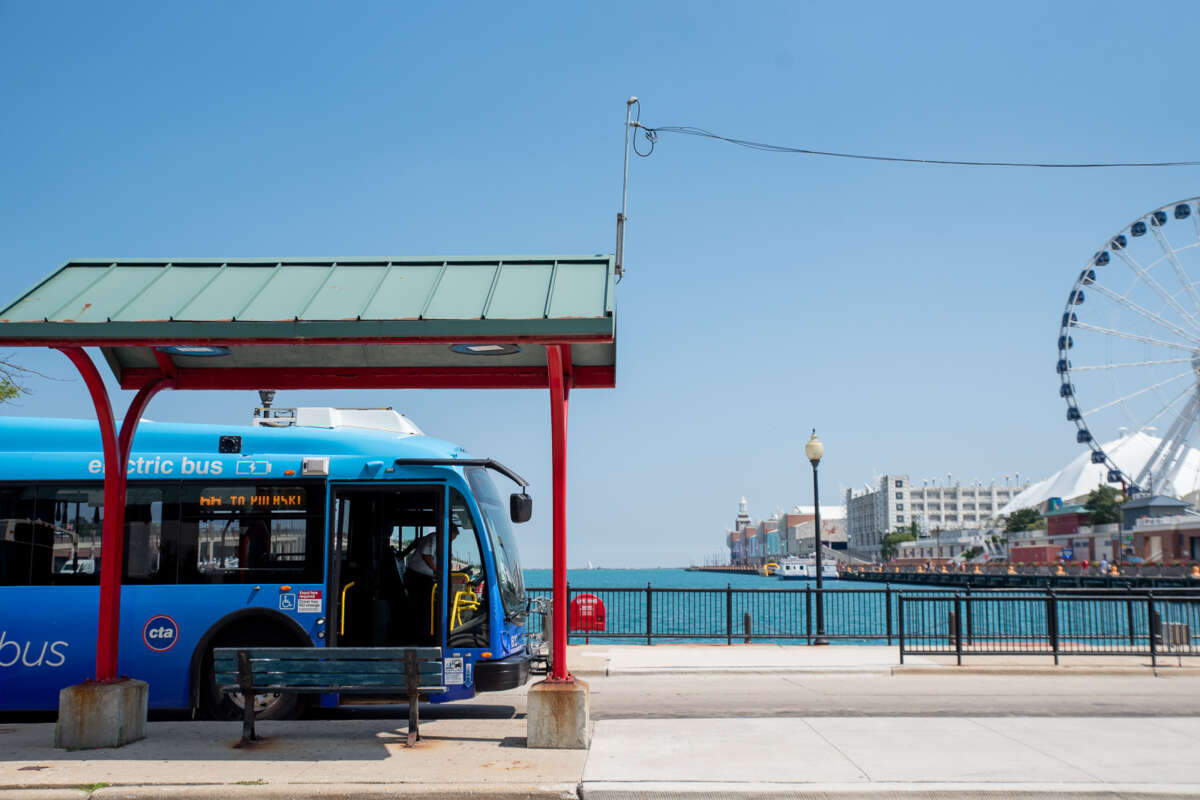 CTA bus parked at Navy Pier bus turnaround with Ferris Wheel and lake visible in background.