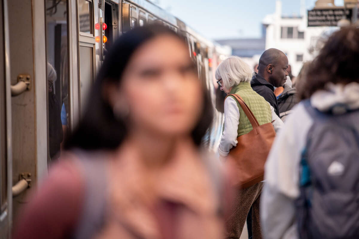 People enter and exit a CTA train, with the woman in the foreground out of focus.