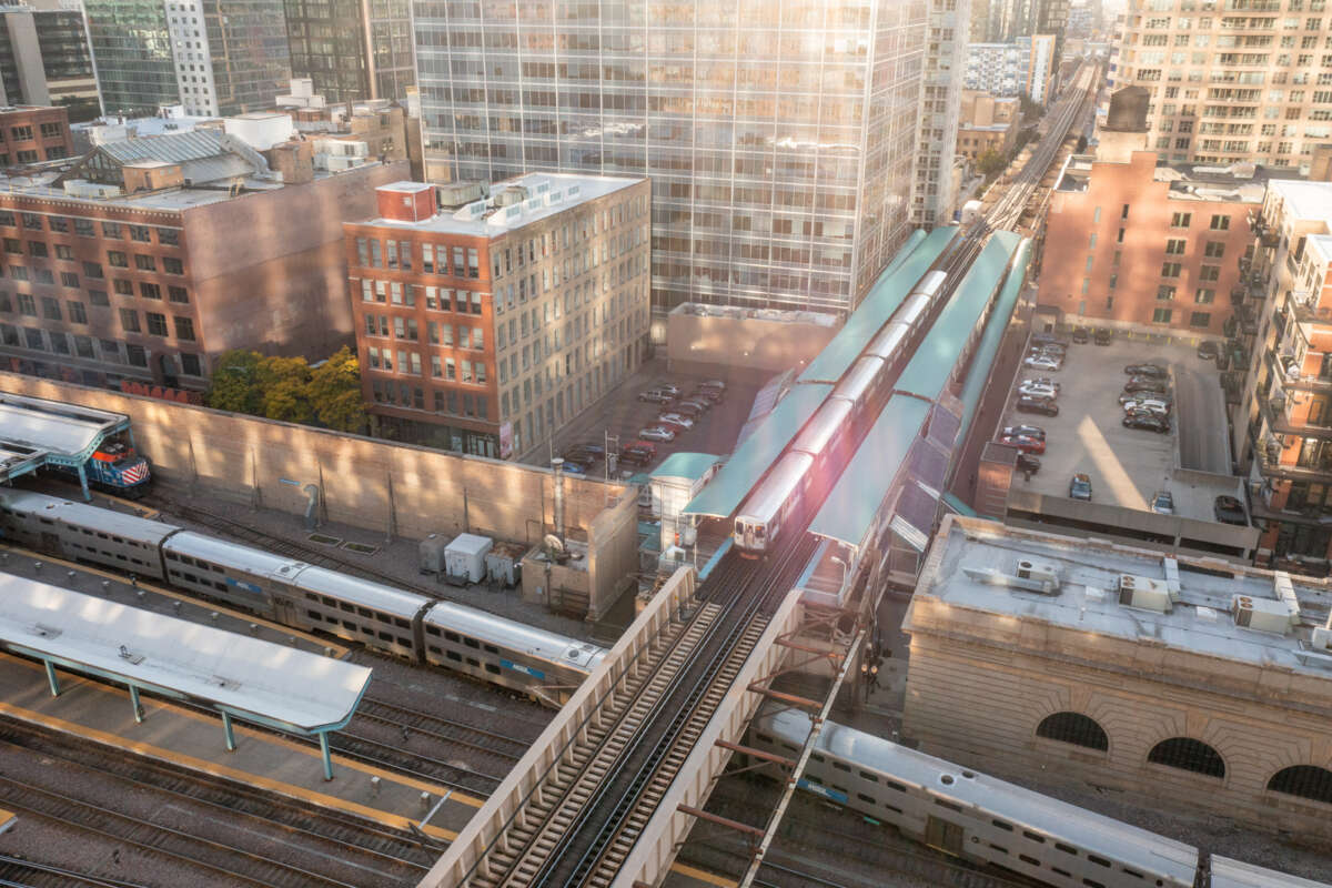 An elevated CTA train crosses a Metra train in downtown Chicago.