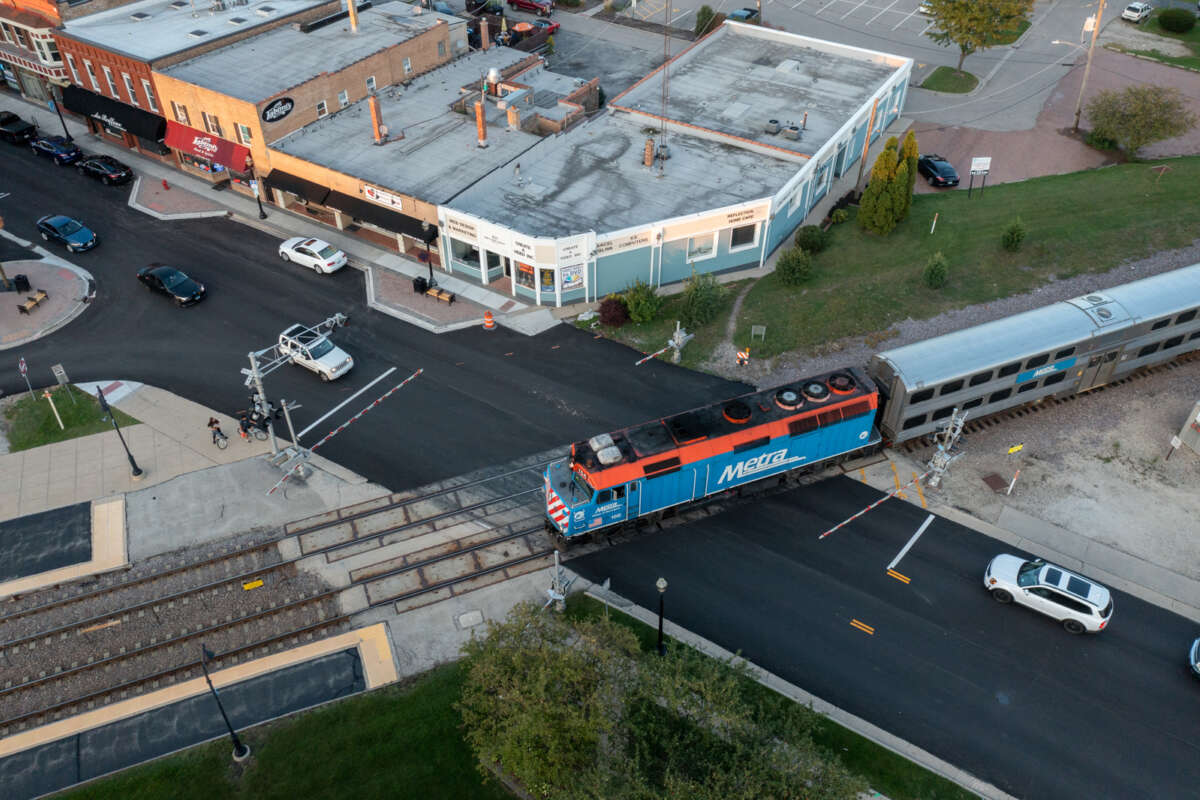Aerial view of a Metra train passing an intersection in Crystal Lake neighborhood.