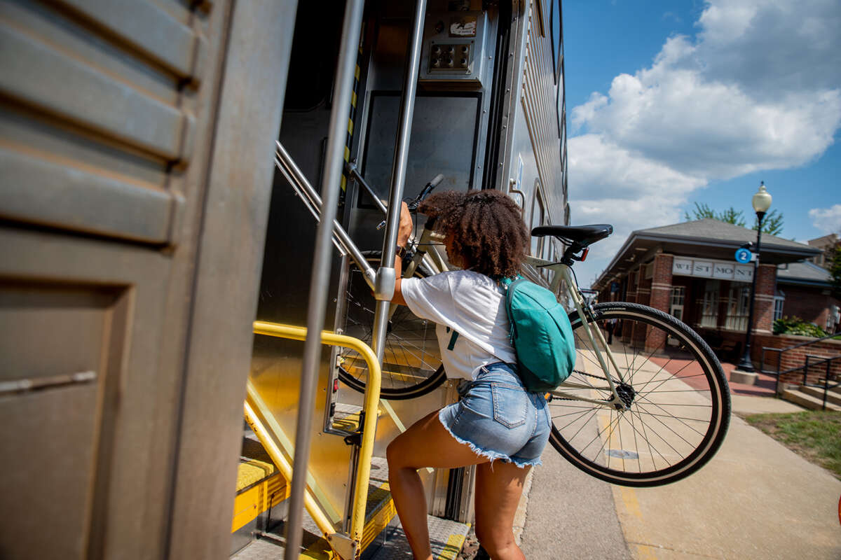 Woman holding bike boarding Metra train.