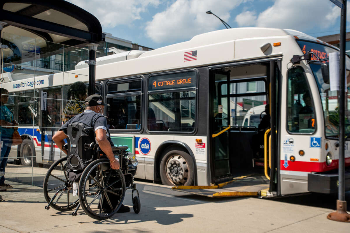 Person in wheelchair about to board onto a handicap lift on a CTA bus.