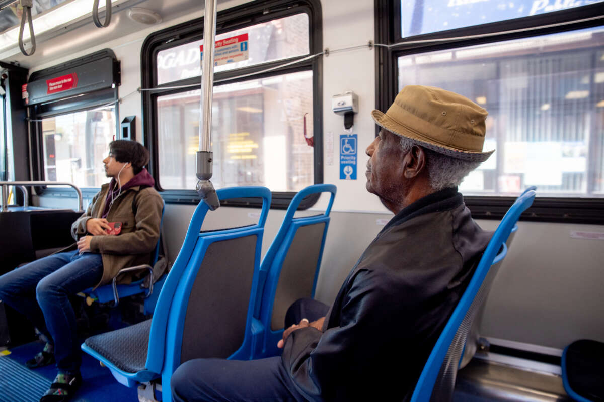 Elderly person sitting on bus.