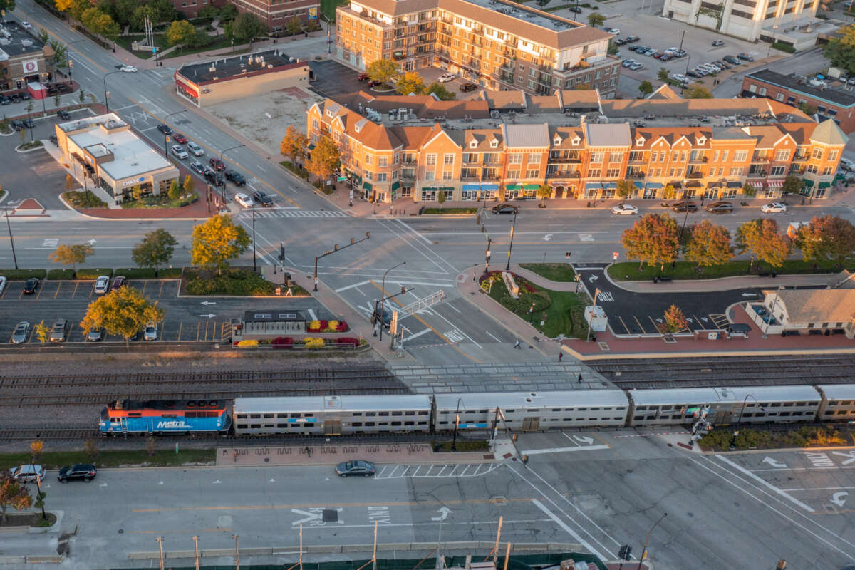 Wide shot of a Metra train with dense developments across the street.